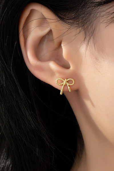 Small textured brass bow stud earrings